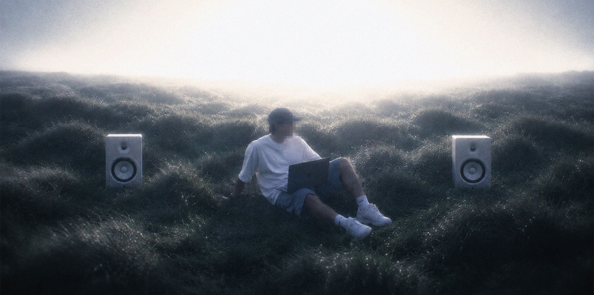 A header image: a figure with a laptop on a misty moor between two studio monitors